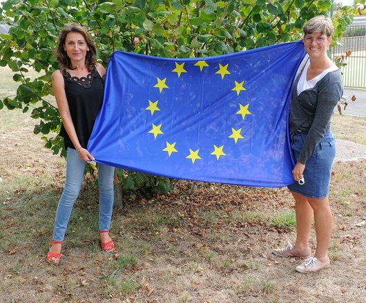 Image de deux agents de la MFR la Rousselière tenant un drapeau européen
